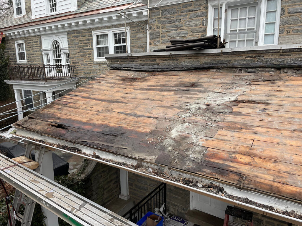 Severely rotted wood roof deck uncovered.