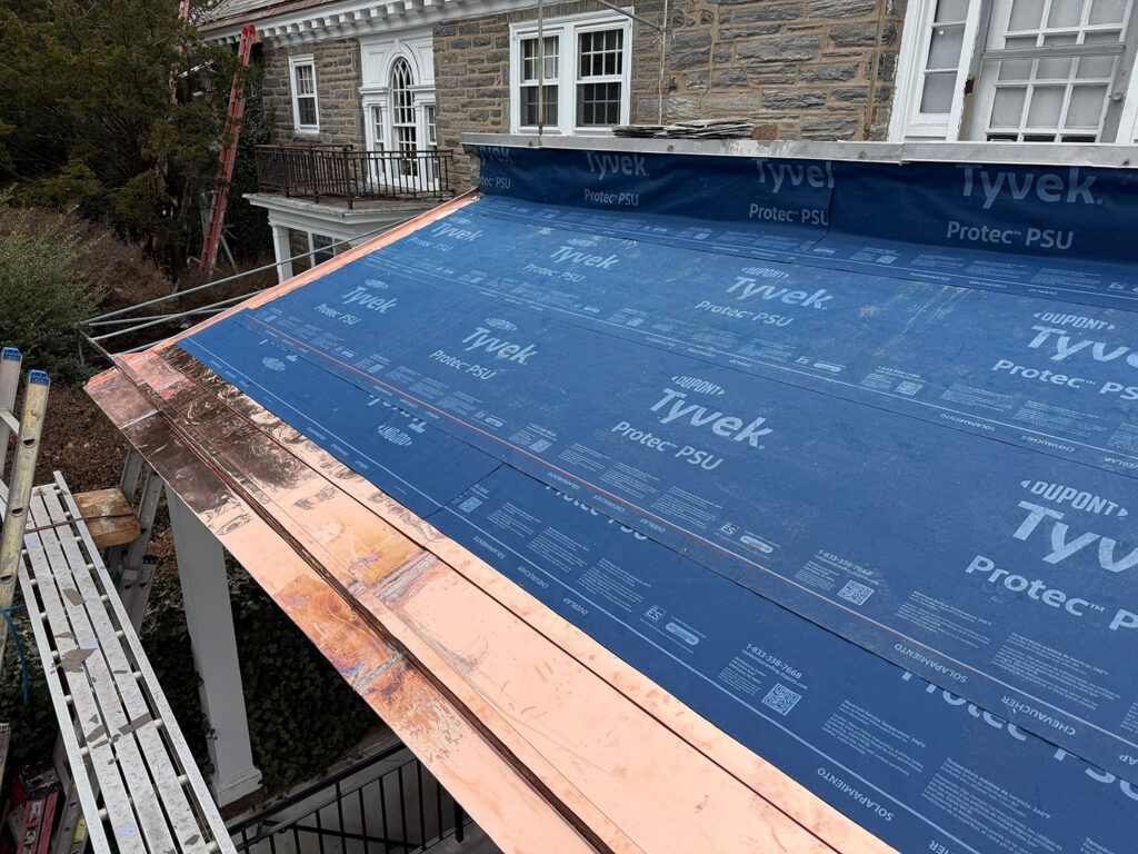 16oz flat seam copper gutter installed with double cleat to receive the standing seam roof.